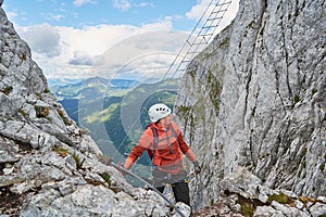 Man climbing via ferrata Intersport near Gosau, just before the well known diagonal ladder