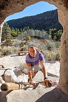 Man Climbing a Wooden Ladder at Bandelier National Monument