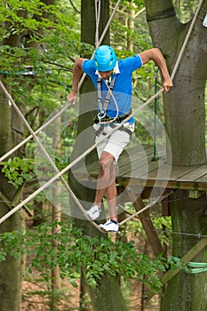 Man climbs over obstacles at high rope court