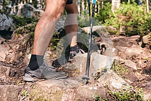 Man climbs in sneakers in outdoor action. Top View of hiking Boot on the trail. Close-up Legs In Jeans And sport trekking shoes on