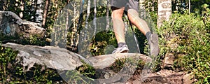 Man climbs in sneakers in outdoor action. Top View of hiking Boot on the trail. Close-up Legs In Jeans And sport trekking shoes on