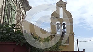 A man climbs the stairs to the bell tower and rings the bells in a village church.