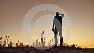 Man climbs on top of a mountain hill on nature silhouette. Travel walking concept tourism. Hiker climbs a hill lifestyle