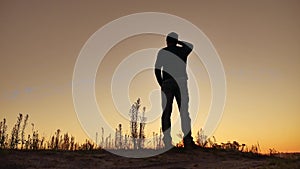 Man climbs on top of a mountain hill on nature silhouette. Travel walking concept tourism. Hiker climbs a hill looks