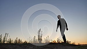 Man climbs on top of a mountain hill on nature silhouette. travel walking concept tourism. hiker climbs a hill looks