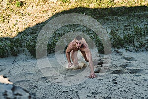 Man climbs up the hill out of the sand