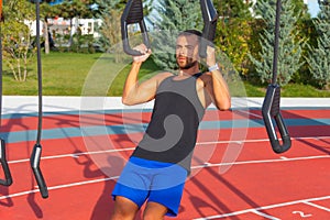 Man climbs a wall with a rope. Rope climbing exercise in a fitness gym in a city park