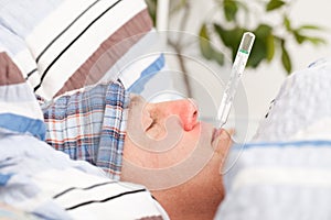 Man with clinical thermometer in his mouth