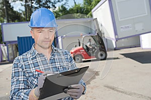 Man with clipboard controlling transport cabins