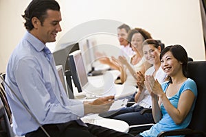 Man with clipboard giving lecture in applauding