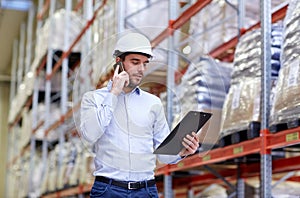 Man with clipboard and smartphone at warehouse