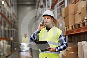 Man with clipboard and smartphone at warehouse