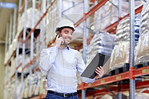 Man with clipboard and smartphone at warehouse