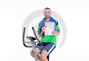 Man with clipboard train on fitness machine