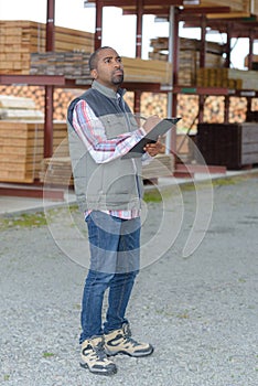 Man with clipboard in woodyard
