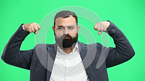 Man, close-up, on a green background, shows strength