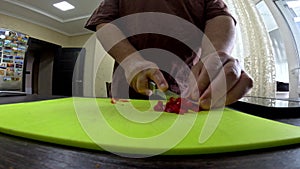 man close up wide angle cutting hot pepper on slice board