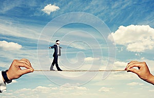 Man with closed eyes balancing on the rope