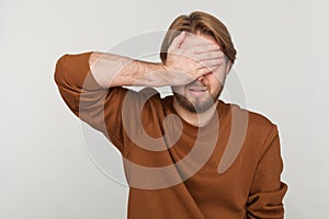 Man closes eyes with hand, dont want to see that, ignoring problems, hides from stressful situations