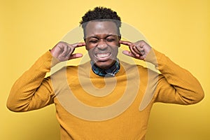 Man closing ears with fingers does not wanting to hear something.