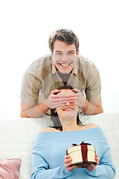 Man closing eye to girlfriend to present gift