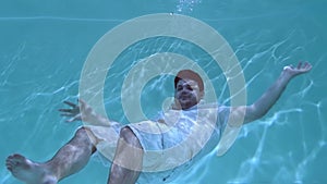 Man in clothes wallows underwater.
