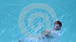 Man in clothes wallows underwater.