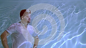 Man in clothes wallows underwater.