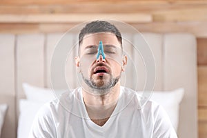 Man with clothespin suffering from runny nose