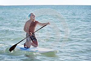 Man in clown mask paddleboarding