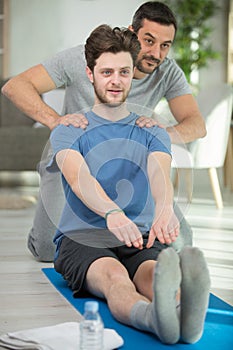 man coach and boy doing exercise at fitness center