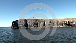 Man on coast and water surface of Arctic Ocean on New Earth Vaigach Island.