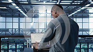 Man coding on data center, testing failover scenarios using notebook