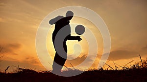 Man coins a ball European the football soccer freestyle silhouette at outdoors sunset sunlight. man beats chasing ball