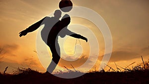 Man coins a ball European the football soccer freestyle silhouette at sunset outdoors sunlight. man beats chasing ball