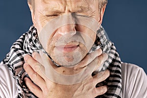 Man with cold and flu illness suffering from sore throat. Blue background