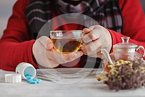 Man Cold / Ill man with scarf and tea cup, sneezing into handkerchief. Medication or drugs abuse, healthcare concept