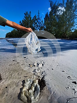 Man collected plastic bag while walking on the beach in Balambangan Island, Kudat.