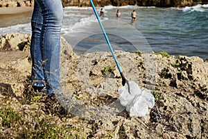 Man collecting garbage next to the beach