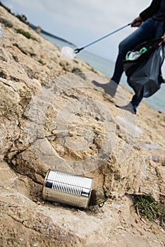 Man collecting garbage with a reach extender