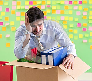 Man collecting his stuff after redundancy in the office with man