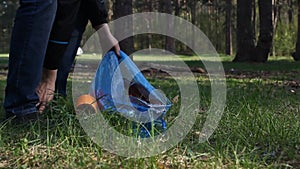 A man collects garbage in the forest in a package