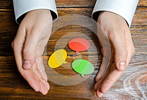 A man collects multicolored speech bubbles in his hands. Listen to other opinions and points of view, accepting criticism