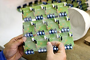 A man collects a printed circuit board. The worker solders the radio components and assembles the finished device. Manual assembly