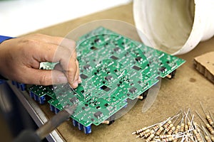 A man collects a printed circuit board. The worker solders the radio components and assembles the finished device. Manual assembly