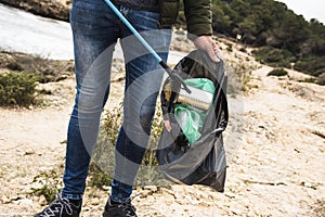 Man collects waste with a reach extender