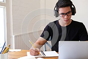 Man college student  studying learning lesson with computer online taking note photo