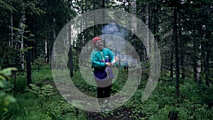 Man with colored smoke bombs in nature. Stock footage. Young man set fire to smoke bombs and they sparkled before smoke