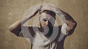 Man comb his hair on wall background. Hair Stylist and Barber. Bearded hipster man with long beard and mustache