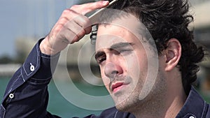 Man Combing Hair Near Ocean